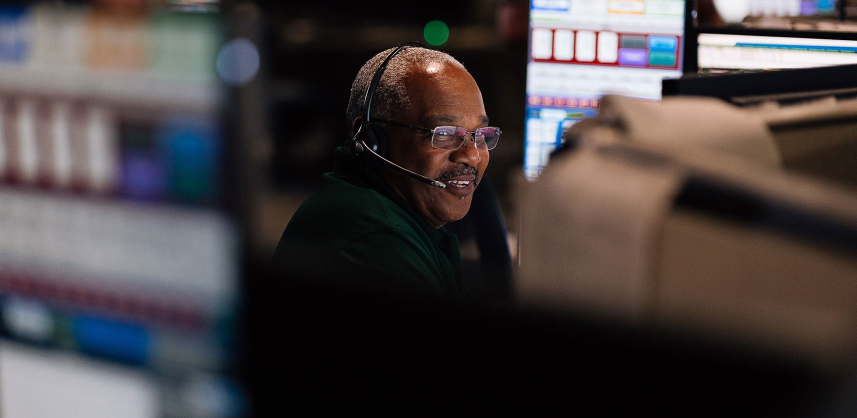 Man with a headset on at a computer